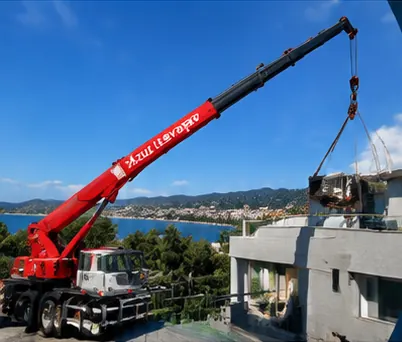 Camion grue à bras télescopique Azur Levage en levage au-dessus d'un immeuble